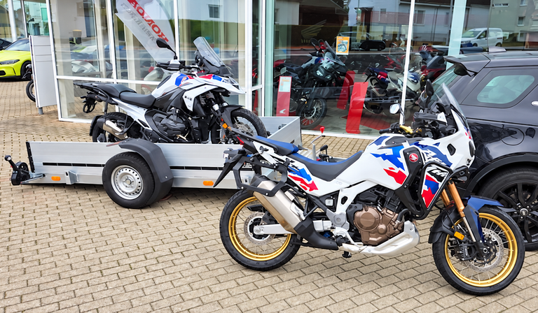 Motorräder und MotoTrailer-Anhänger vor einem Autohaus
